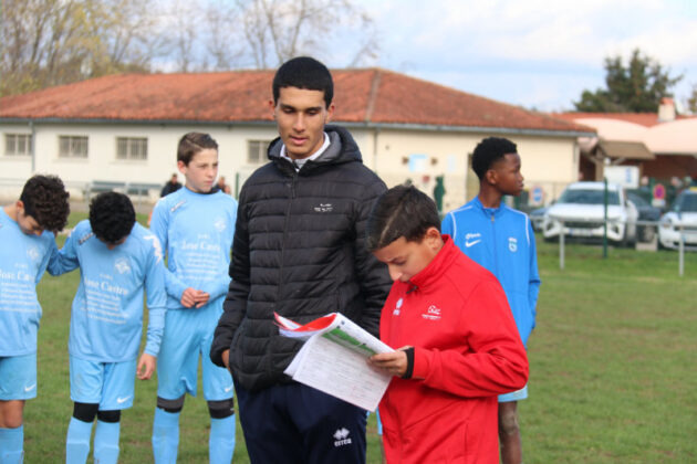 L'entraîneur Ismaël Moha et un jeune joueur lisant la charte_Crédit photo Jpb