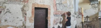 Sylvie Lemozy devant les peintures médiévales découvertes lors de la restauration de l'église d'Espis, près de Moissac.