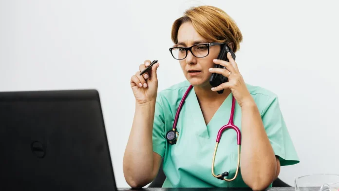 Un infirmier spécialisé renforce la régulation des appels au 15 Professionnelle de santé au téléphone au sein d'un service de régulation médicale.