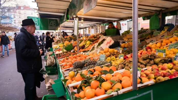 Transport des seniors vers le marché de Montauban Un homme âgé devant un étal de fruits sur un marché
