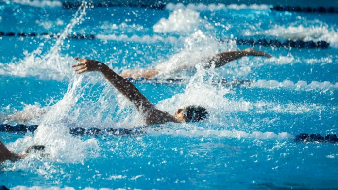 Nageurs en compétition dans une piscine, dans plusieurs couloirs de nage