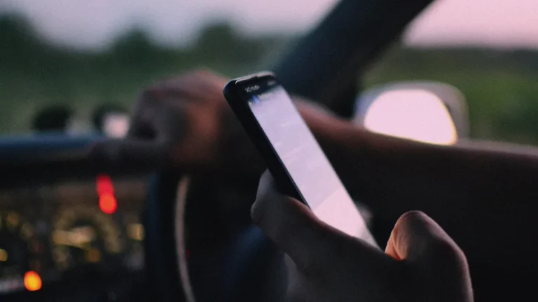Conducteur utilisant un téléphone tenu en main au volant d'une voiture
